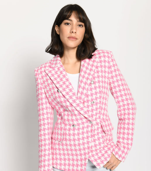 Model trägt leicht taillierten Damenblazer mit kräftigem Pepita-Muster in Rosa und Weiß – stehende Pose, Blick nach vorne