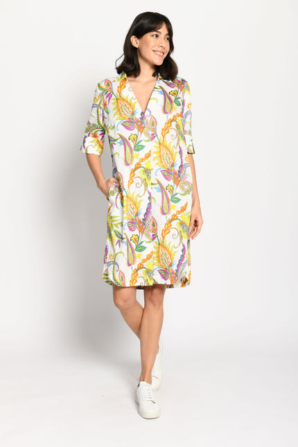 Model trägt knieumspielendes, luftiges Baumwollkleid mit farbenfrohem Muster auf weißem Untergrund – Vorderansicht