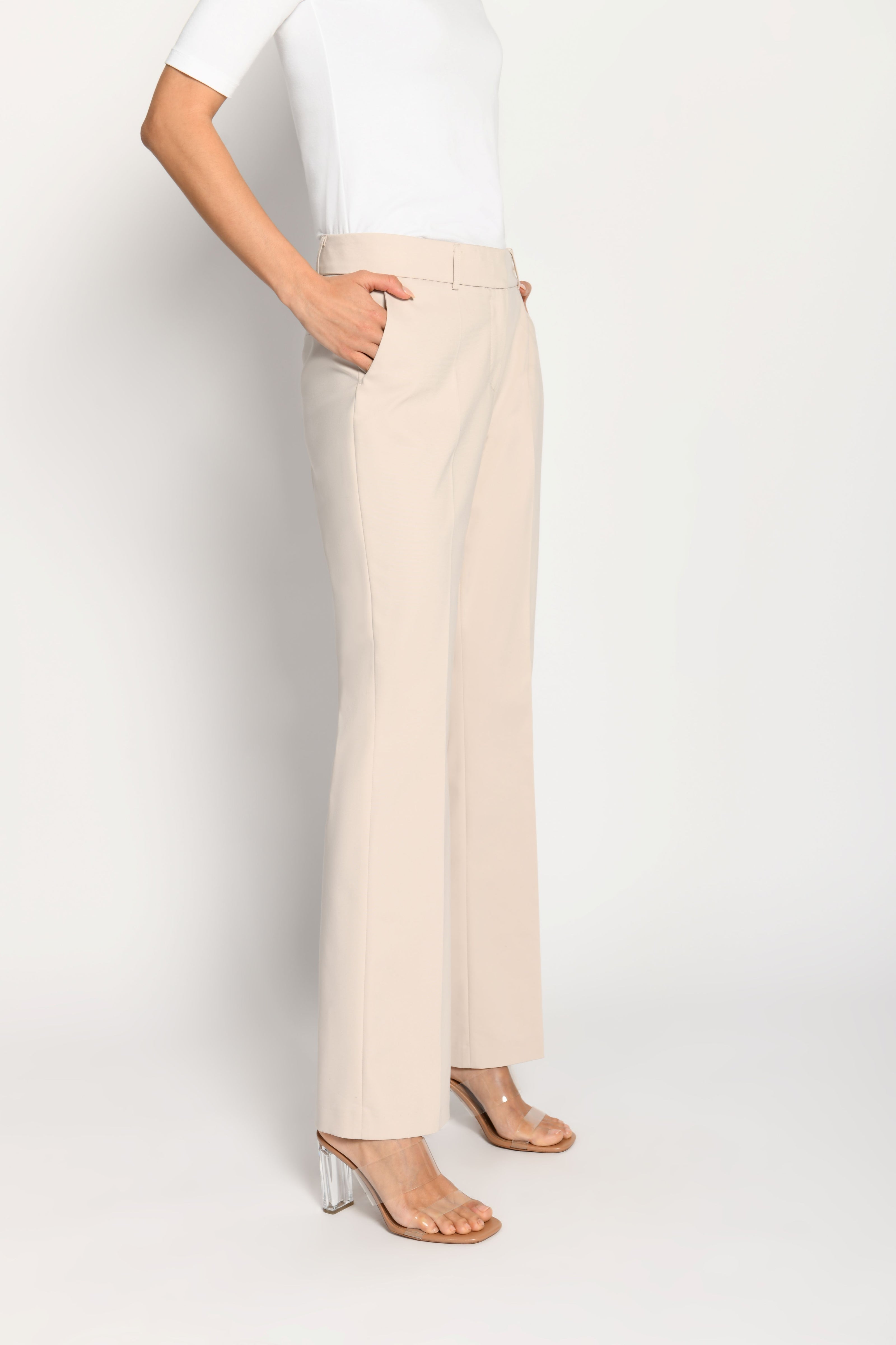 Model trägt beige Stoffhose für Damen mit Buntfalte – stehende Pose, Seitenansicht links