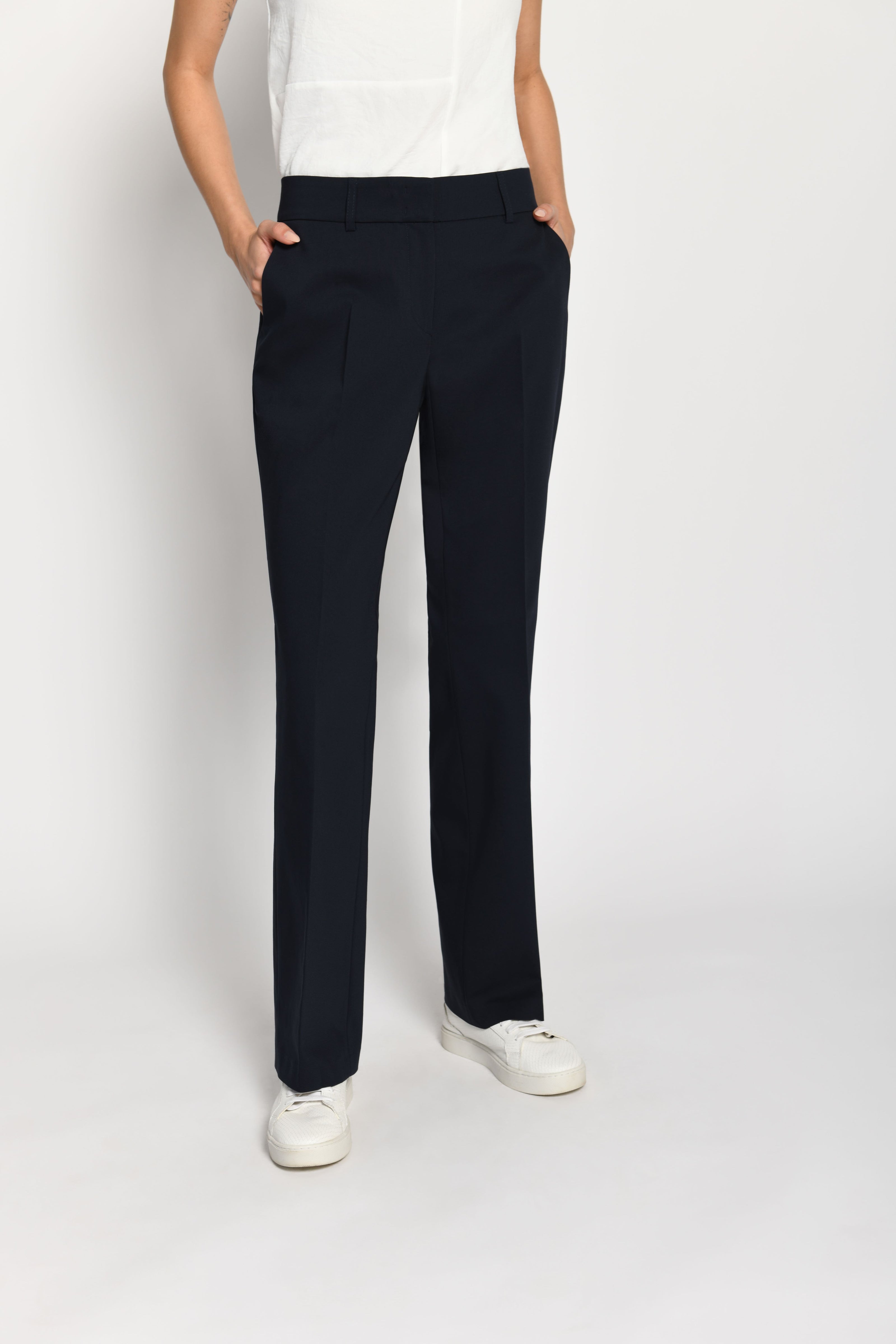 Model trägt dunkelblaue Stoffhose für Damen mit Buntfalte – stehende Pose, Vorderansicht