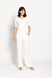 Model trägt weiße Marlene-Hose für Damen mit Buntfalte – stehende Pose, Blick nach rechts