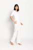 Model trägt weiße Marlene-Hose für Damen mit schmalen Leistentaschen – stehende Pose, Blick nach vorne