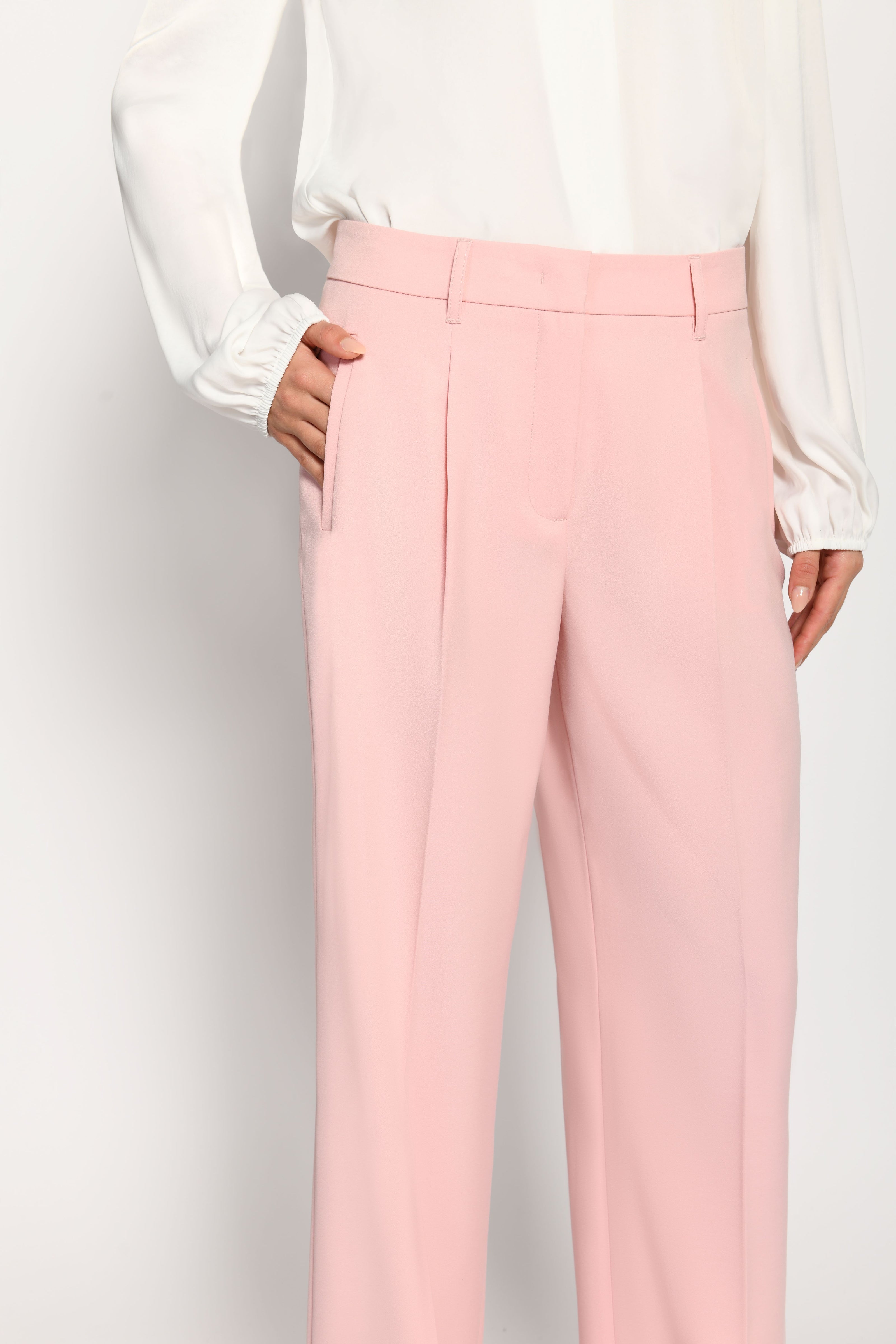 Nahaufnahme der rosafarbenen Marlene-Hose mit sichtbaren Gürtelschlaufen und seitlicher Leistentasche – Vorderansicht