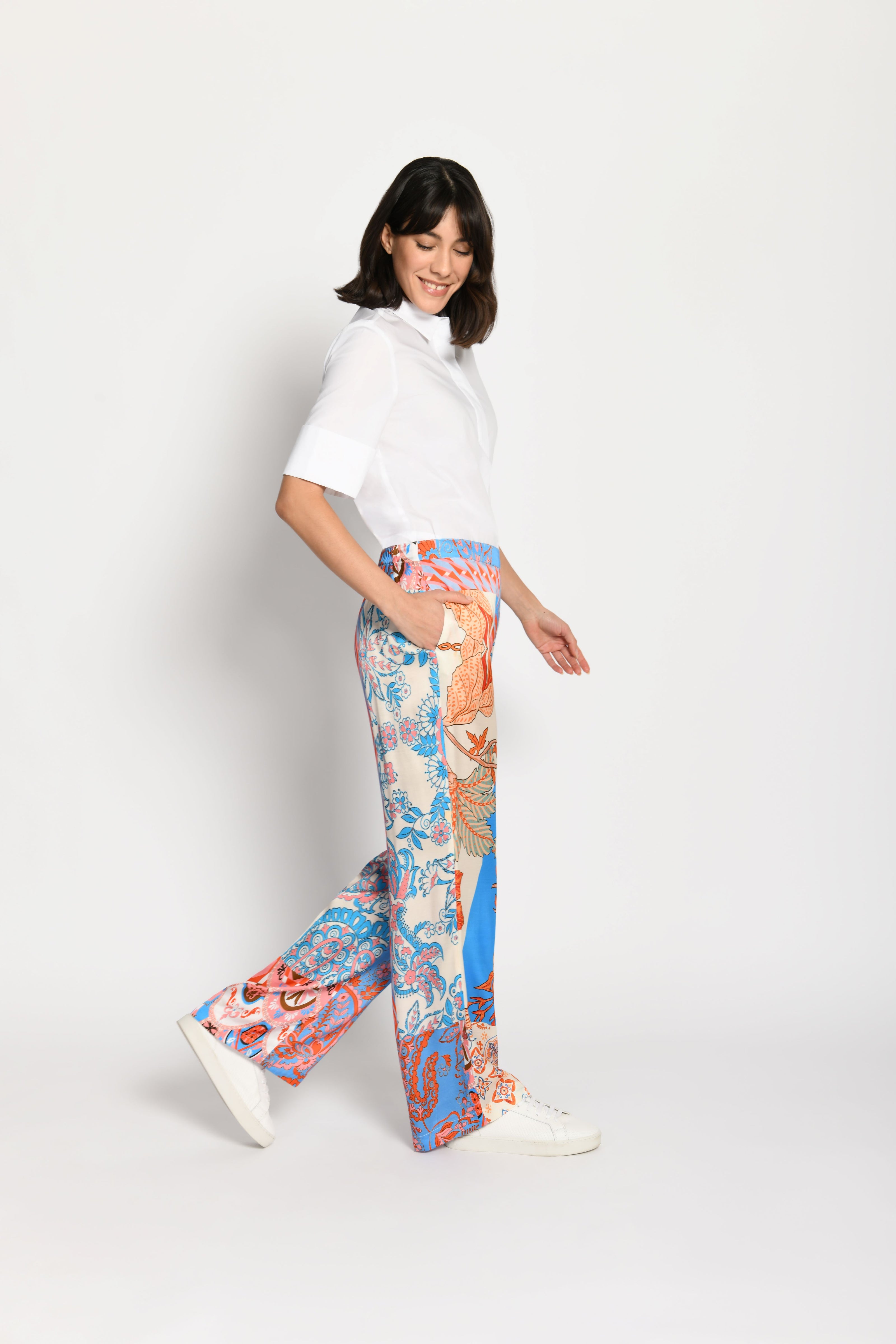 Model trägt Palazzo-Hose mit farbenfrohem Patchdruck – Seitenansicht von links