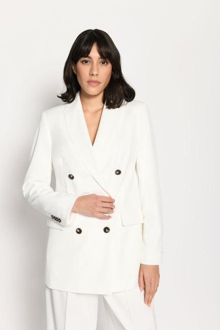 Model trägt taillierten Damenblazer in der Farbe Weiß in Kombination mit passender weißer Stoffhose – Vorderseite sichtbar