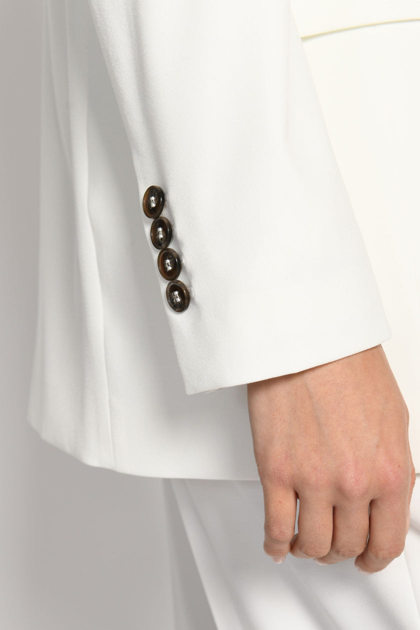 Nahaufnahme des linken Ärmels mit geknöpftem Ärmelschlitz. Vier schwarze Knöpfe sichtbar – Seitenansicht