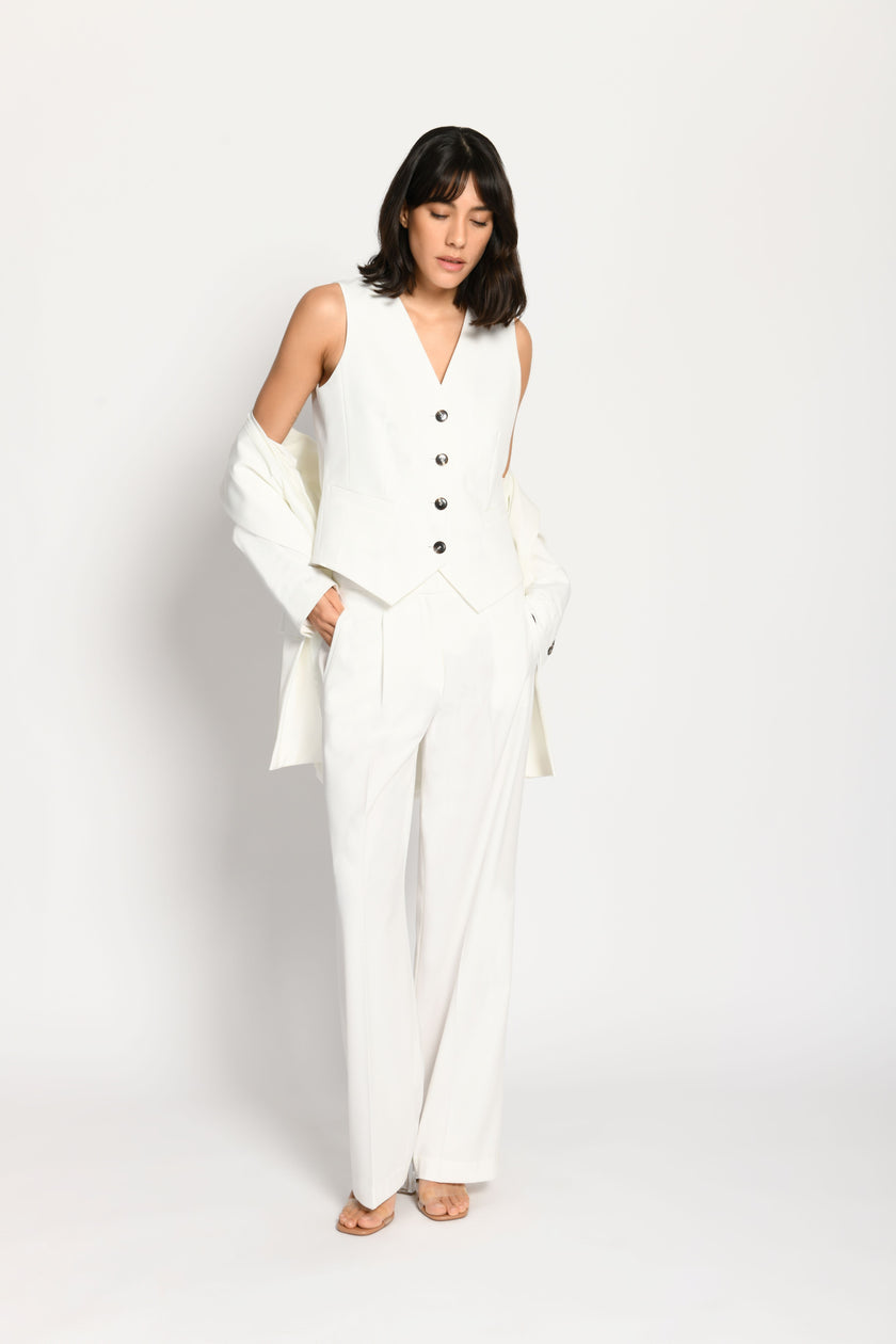 Model trägt taillierten weißen Damenblazer in Kombination mit passender weißer Stoffhose und Weste – Vorderseite sichtbar
