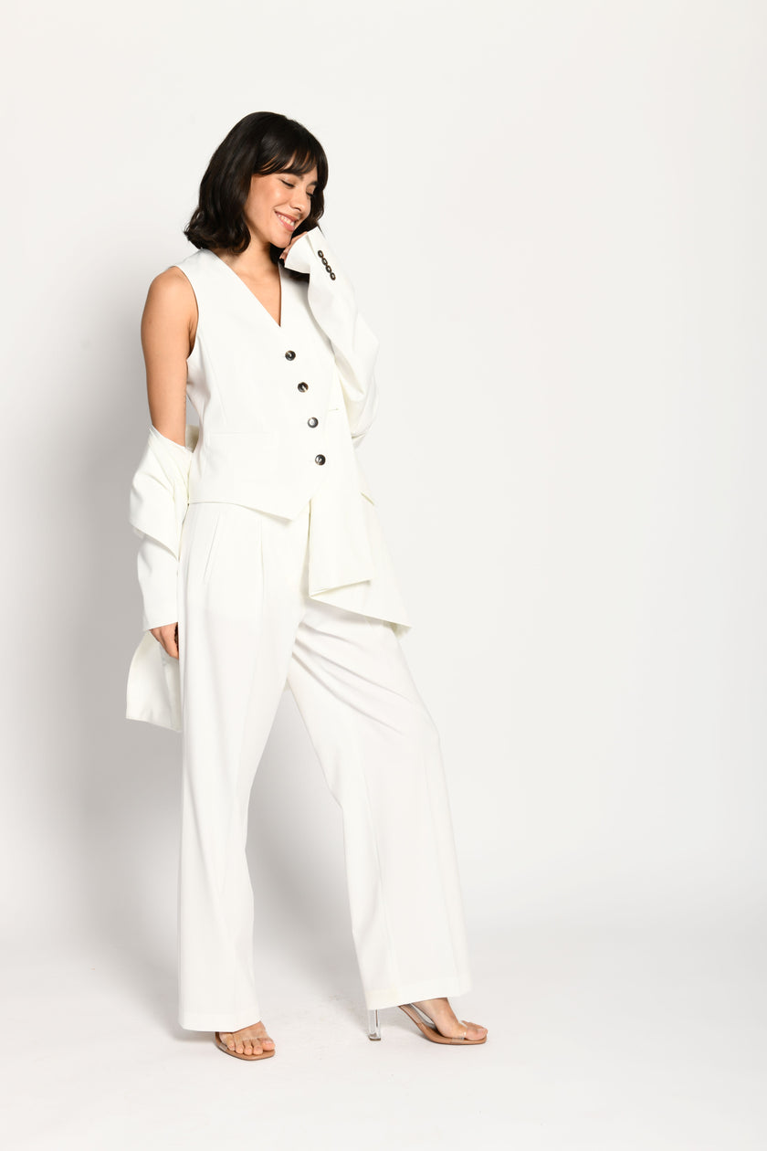Model trägt taillierten weißen Damenblazer in Kombination mit passender weißer Stoffhose und Weste – Seitenansicht von links