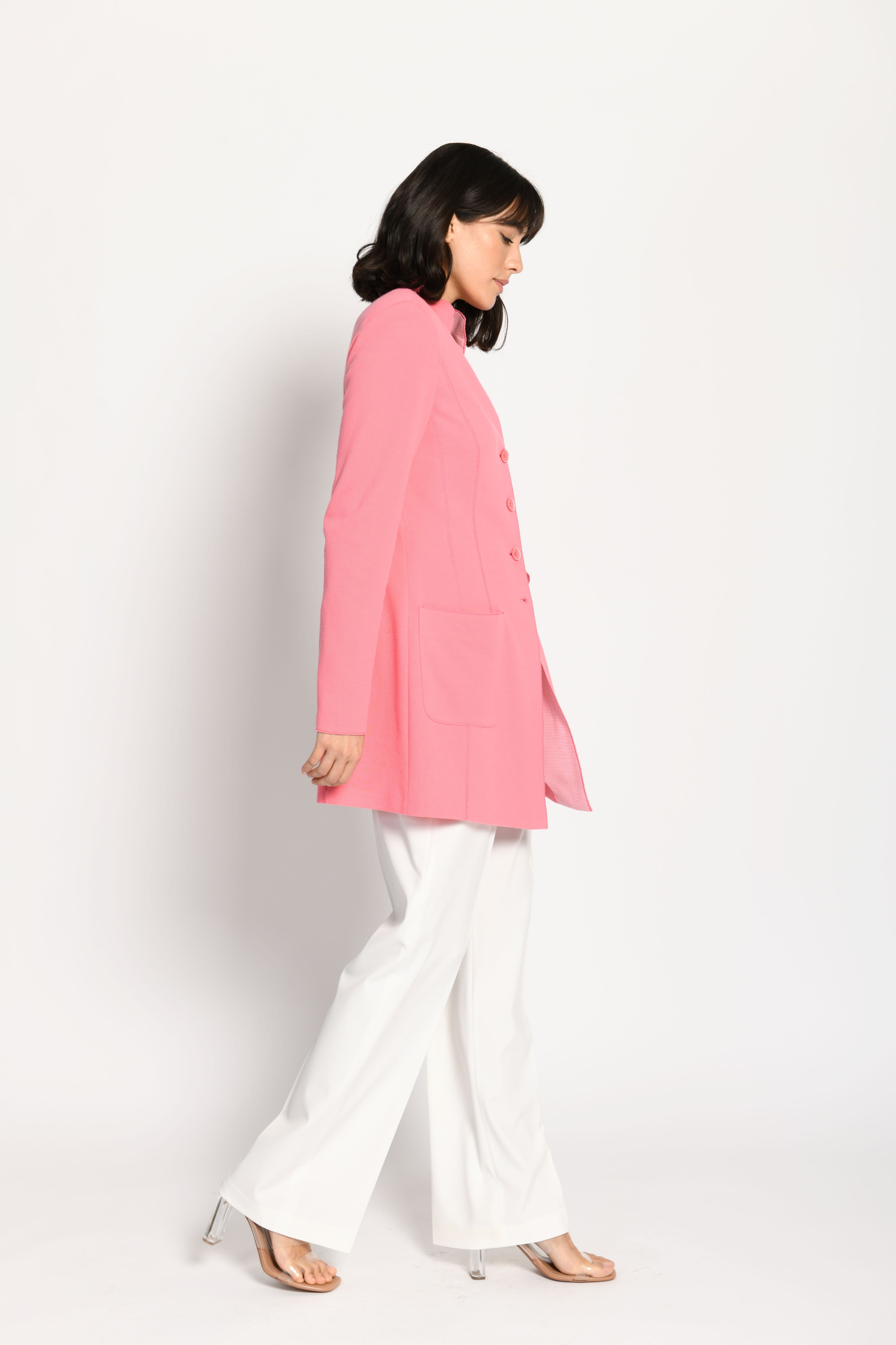 Model trägt taillierte, klassische Longjacke in der frischen Farbe Rosa – Seitenansicht von links, Blick gesenkt