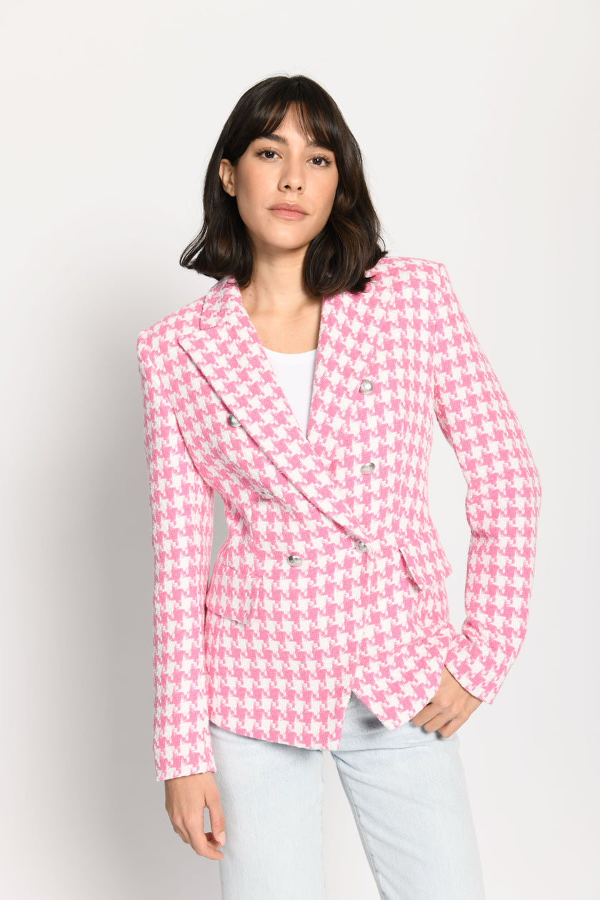 Model trägt leicht taillierten Damenblazer mit kräftigem Pepita-Muster in Rosa und Weiß – stehende Pose, Blick nach vorne