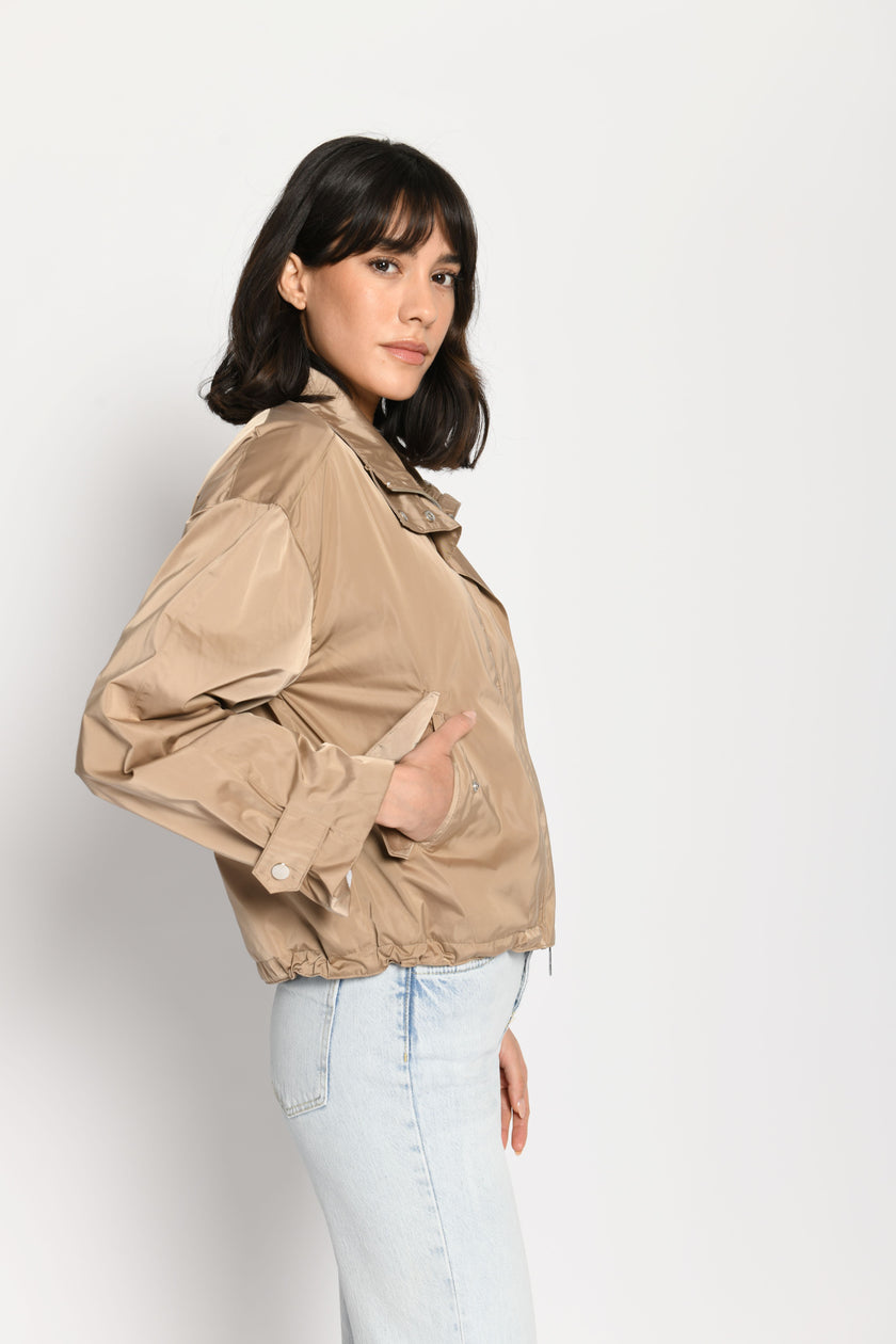 Lässig geschnittene braune Damenjacke mit Hand in der Tasche – stehende seitliche Pose