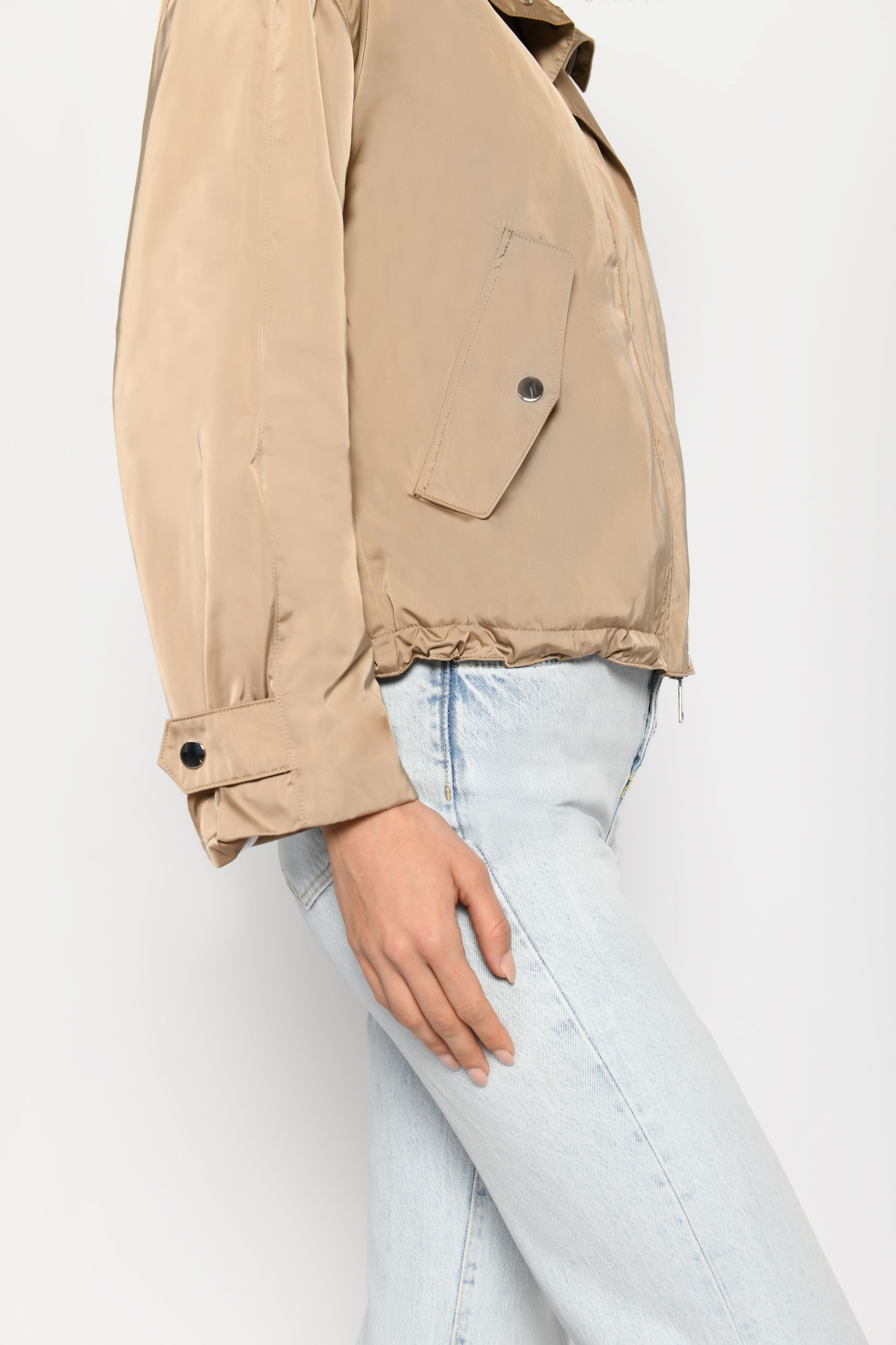 Detailaufnahme zeigt Ärmelriegel und seitliche Eingriffstaschen der Damenjacke  – stehende seitliche Pose, links