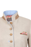 Detailaufnahme der Vorderseite zeigt beigen Janker mit blauen Akzenten, braunen Knöpfen und farbigem Einstecktuch