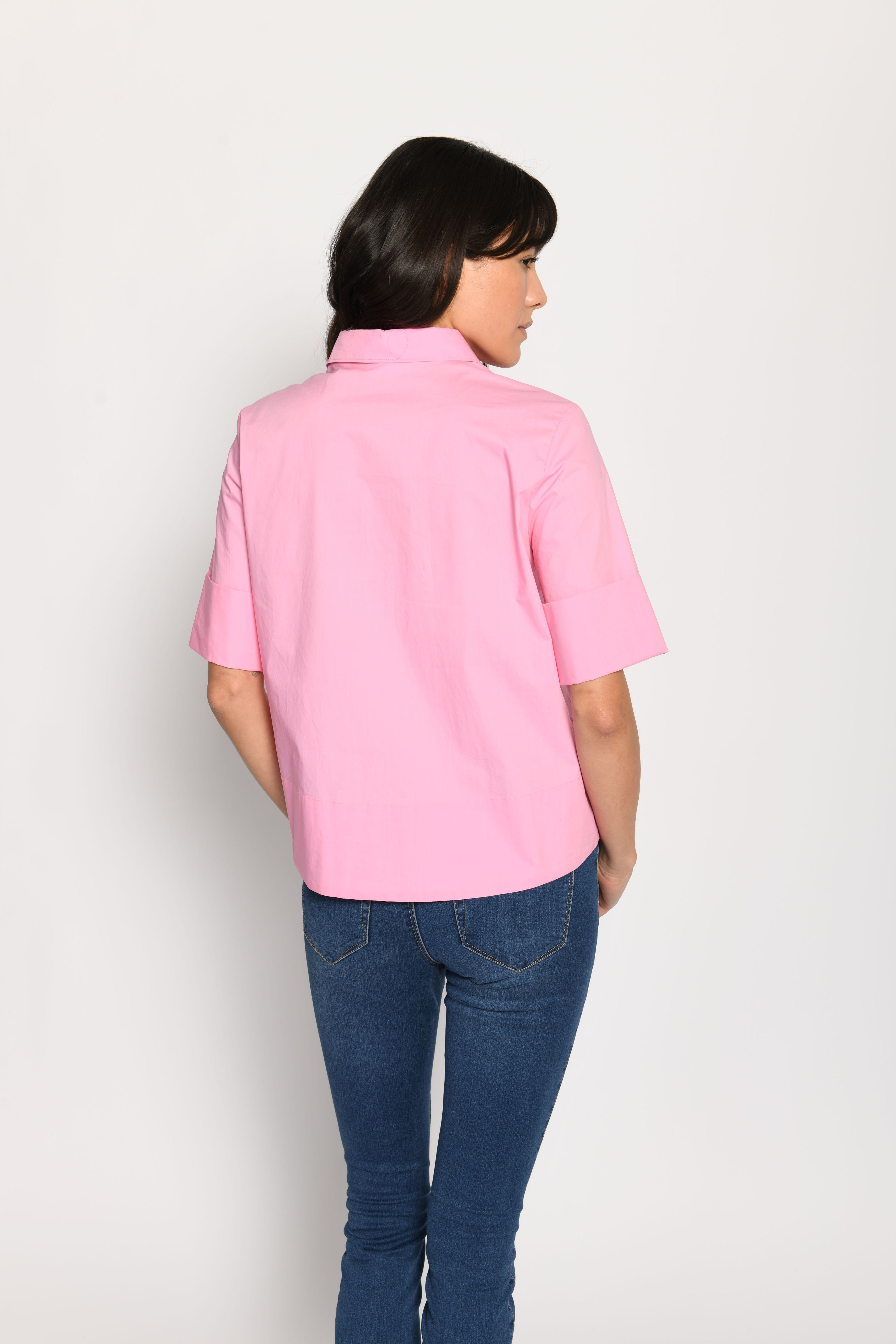 Model trägt kurze kastige Boxy-Bluse in der Farbe Pink mit kurzen Ärmeln, passend zu einer Jeans – Rückansicht