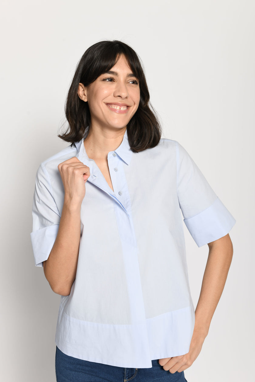 Model trägt kurze kastige Boxy-Bluse in der Farbe Hellblau mit kurzen Ärmeln, passend zu einer Jeans – Nahaufnahme