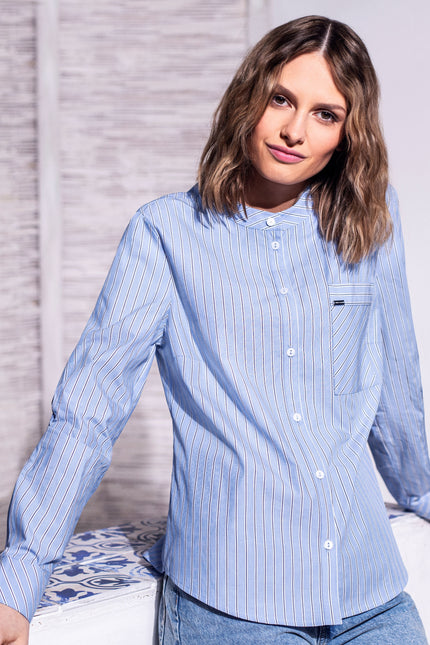 Model trägt hellblaue Bluse mit Längsstreifen zu einer passenden Jeanshose – Vorderansicht