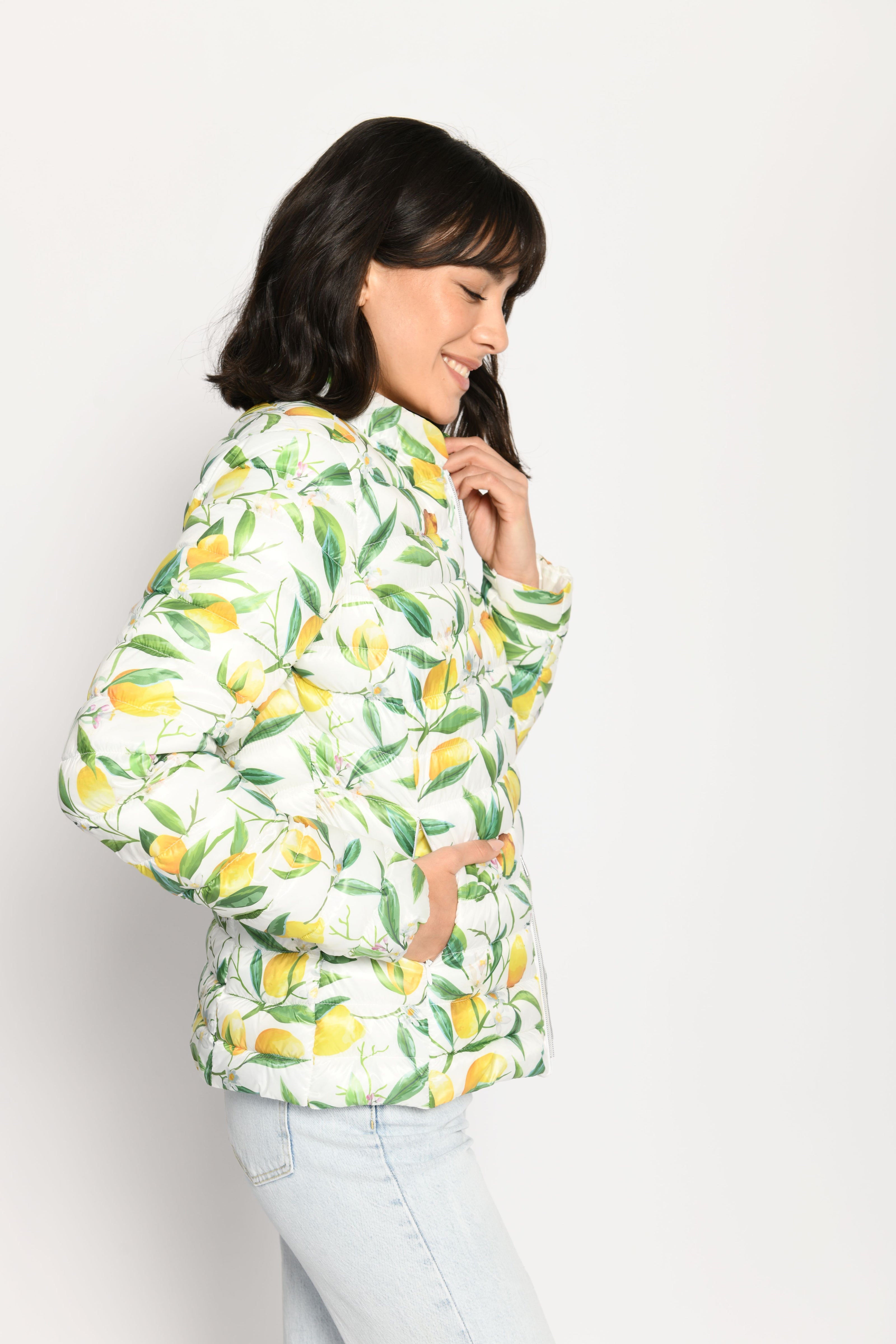 Model trägt leichte Steppjacke für Damen mit kräftigem Zitronen-Print auf weißer Jacke – Seitenansicht von links