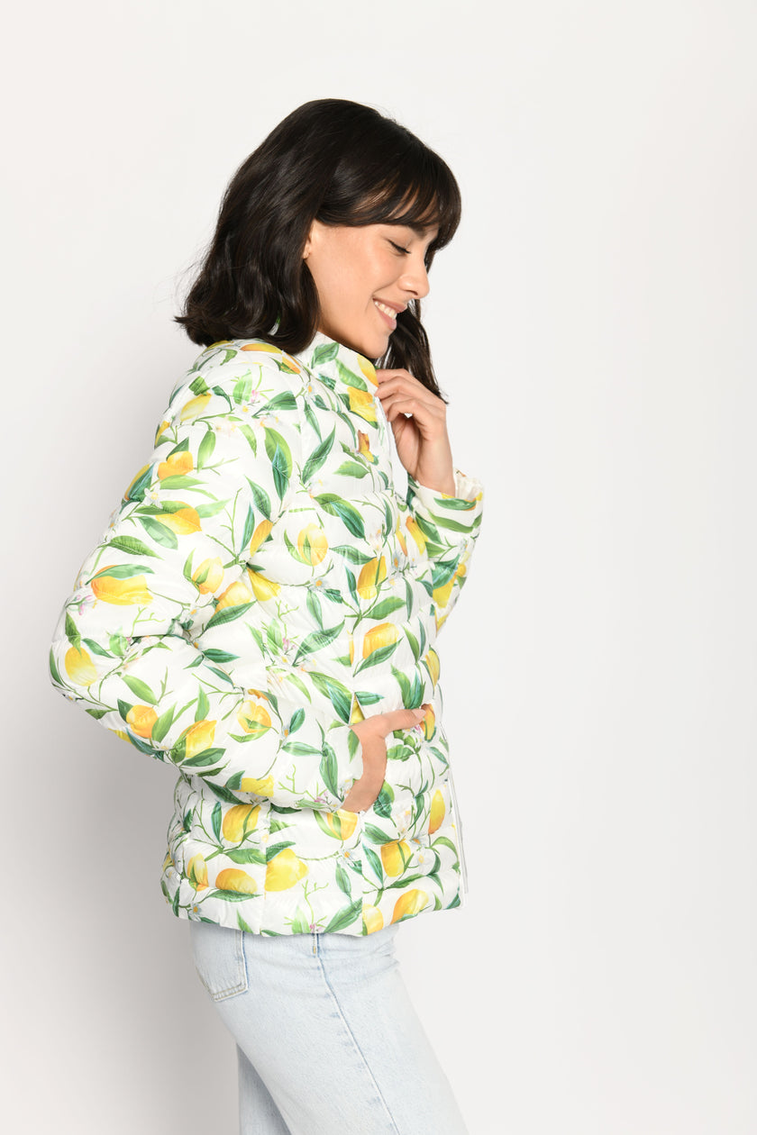 Model trägt leichte Steppjacke für Damen mit kräftigem Zitronen-Print auf weißer Jacke – Seitenansicht von links