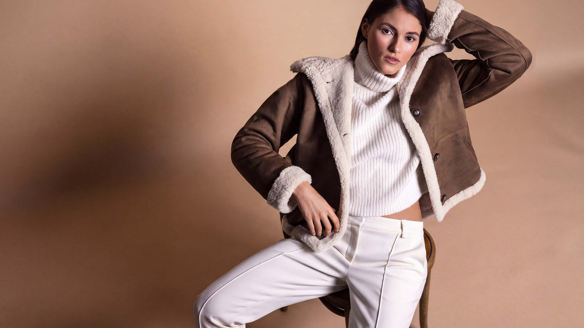 Model trägt Lammfellimitat Jacke in braun.