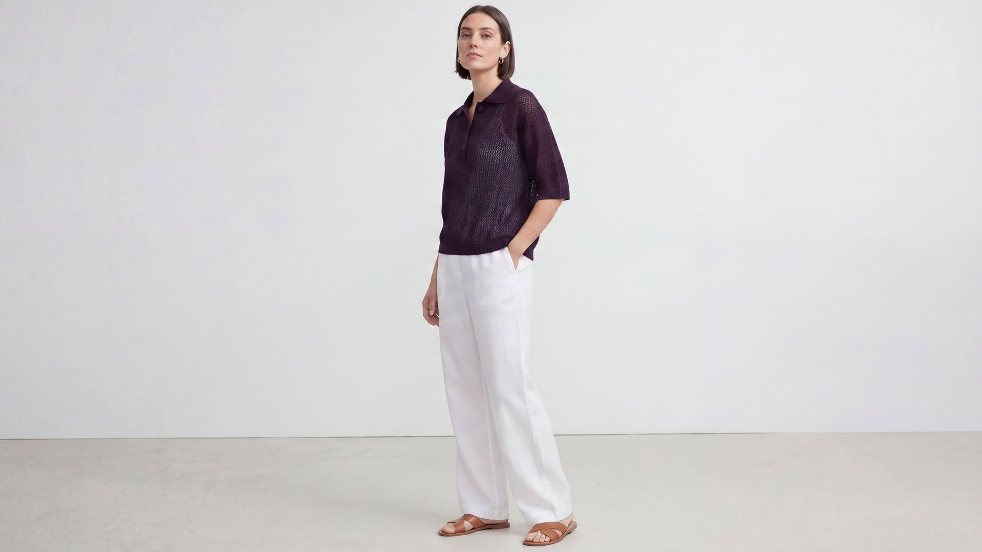 Model trägt sommerliches Poloshirt aus Ajour-Strick. 