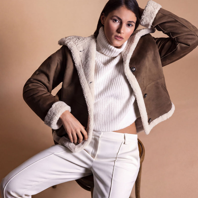 Model trägt eine braune Lammfellimitat Jacke.