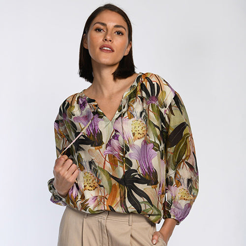 Das Model trägt eine Bluse mit floralem Muster aus leichter Seidenmischung.