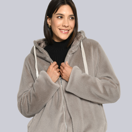 Model trägt wunderschöne Wendejacke aus Webpelz mit Kapuze.