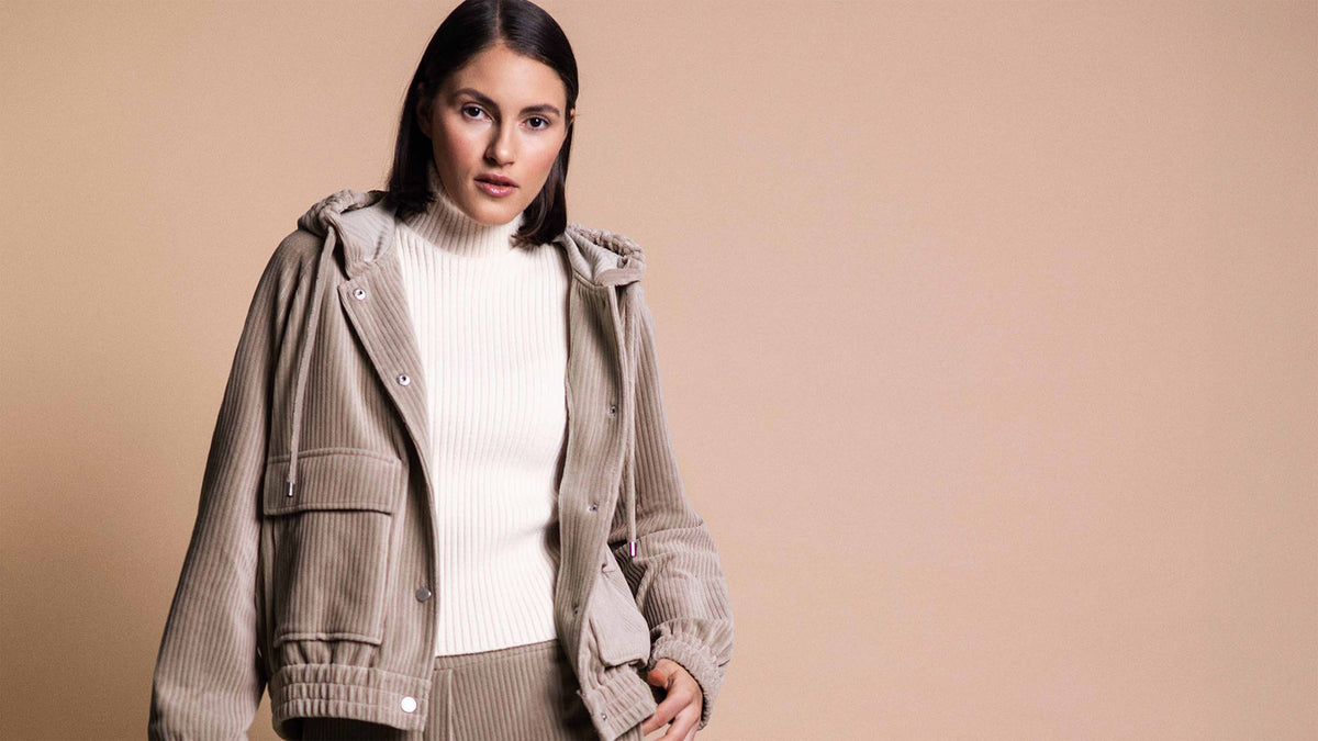 Model trägt lässige Cord Jacke mit Kapuze in beige.