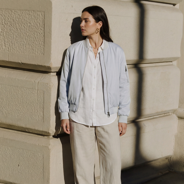 Model trägt hellblaues, locker geschnittenes Blouson.