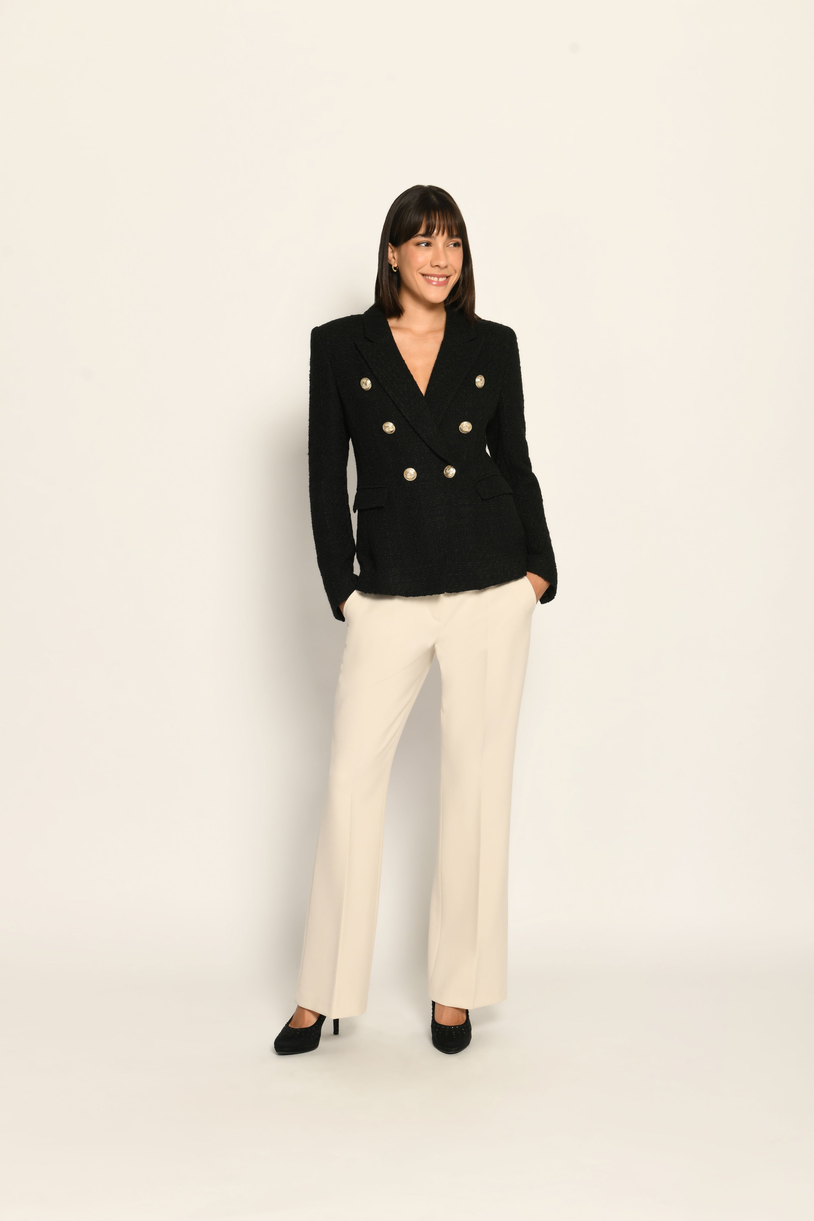 Zweireihiger schwarzer taillierter Bouclé-Blazer für Damen, kombiniert mit beiger Stoffhose – Vorderansicht