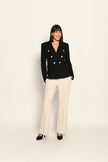 Zweireihiger schwarzer taillierter Bouclé-Blazer für Damen, kombiniert mit beiger Stoffhose – Vorderansicht
