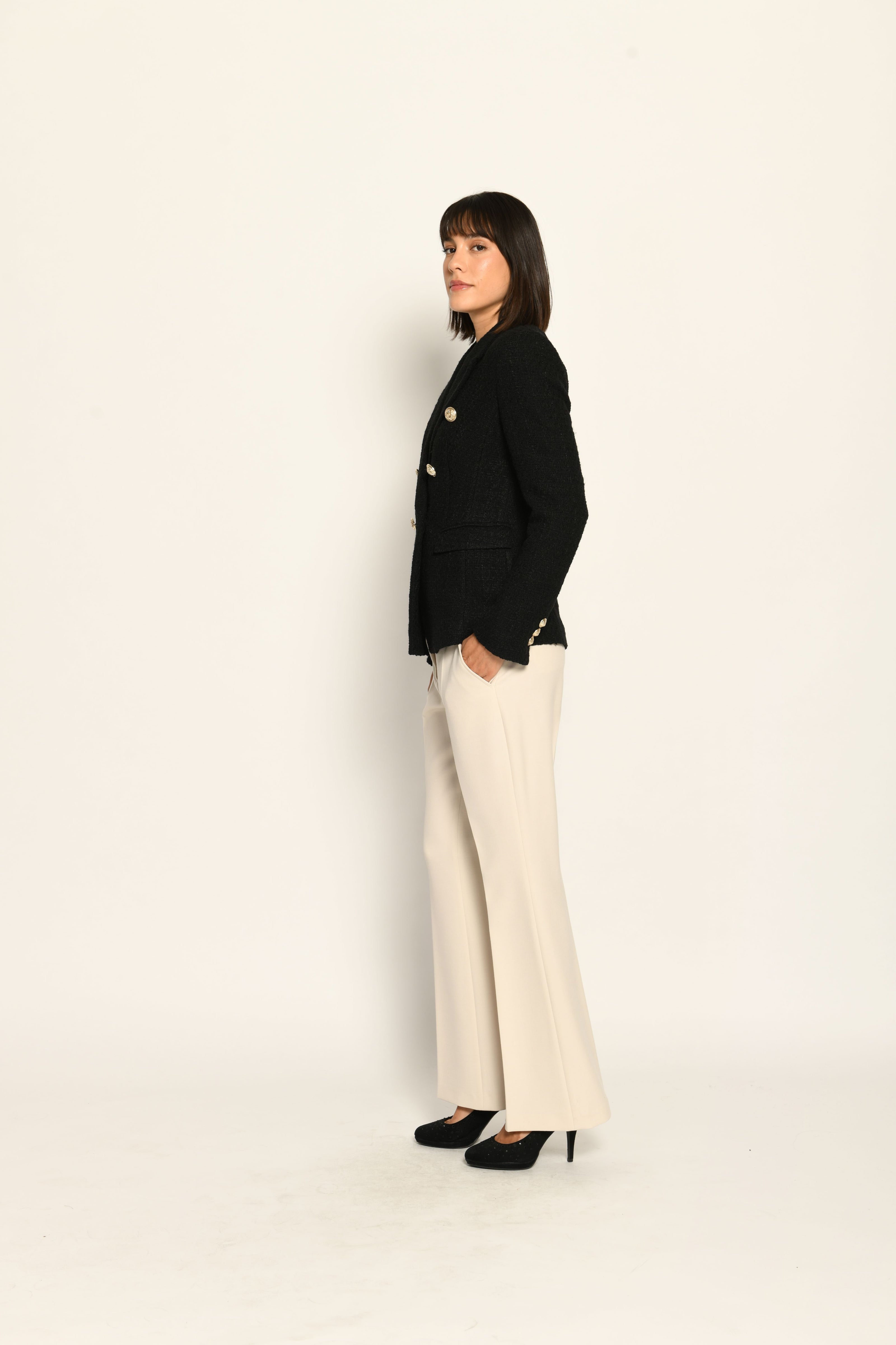 Zweireihiger schwarzer taillierter Bouclé-Blazer für Damen, kombiniert mit beiger Stoffhose – Seitenansicht rechts