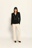 Zweireihiger schwarzer taillierter Bouclé-Blazer für Damen, kombiniert mit beiger Stoffhose – Vorderseite