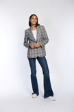 Model trägt Blazer im Boyfriend-Look mit Karomuster in Kombination mit Shirt und Jeans.
