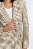 Detailaufnahme eines zweireihigen Blazers im zeitlosen Pepita-Muster mit Pattentaschen.