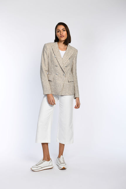 Model trägt tailliert geschnittenen Blazer mit Pepita-Muster und Pattentaschen.