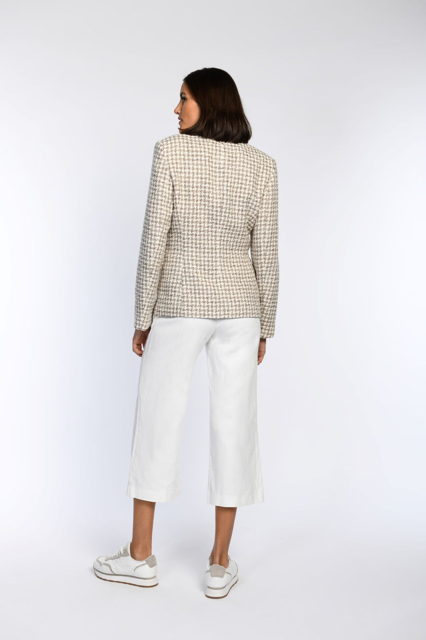 Das Model zeigt die Rückenansicht eines taillierten Blazers im klassischen Pepita-Muster.