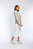 Seitenansicht: Model in Blazer mit Pepita-Muster und Pattentaschen.