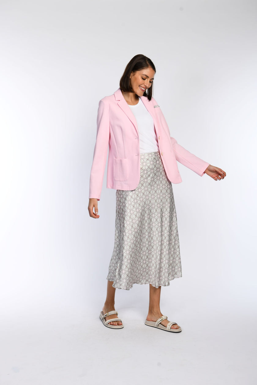 Model trägt rosafarbenen Jersey-Blazer mit aufgesetzten Taschen, kombiniert mit einem pastellfarbenen Rock.