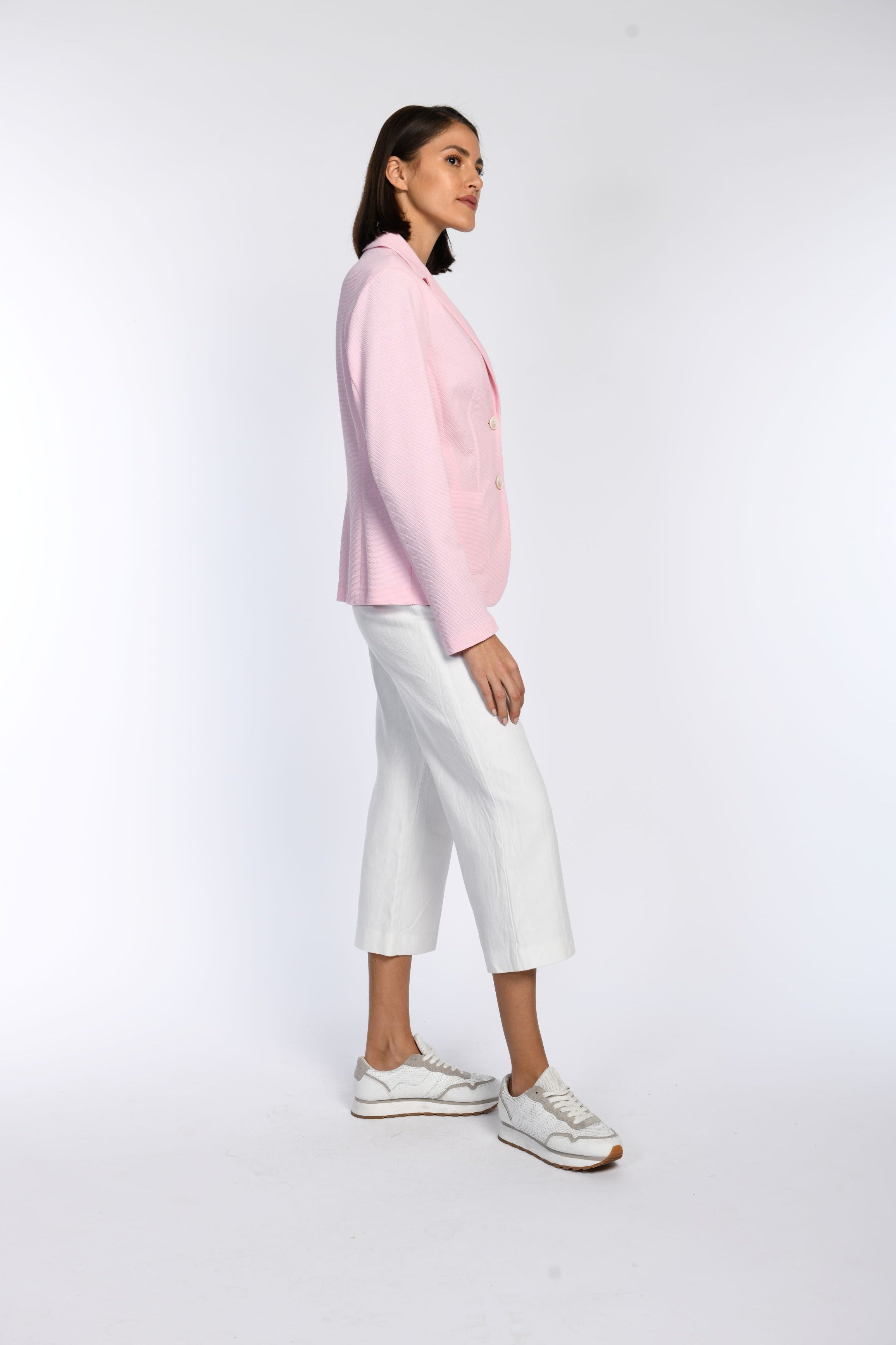 Das Model trägt einen rosa Blazer aus Baumwoll-Jersey, tailliert geschnitten, mit klassischem Reverskragen.