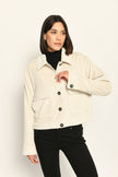 Cord-Blouson in der Farbe Creme mit großen Taschen und schwarzen Knöpfen, kombiniert zu schwarzer Hose – Vorderansicht