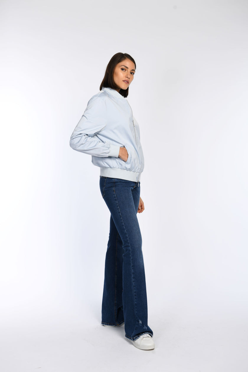 Seitenansicht: Model trägt blauen Blouson mit schrägen Leistentaschen.
