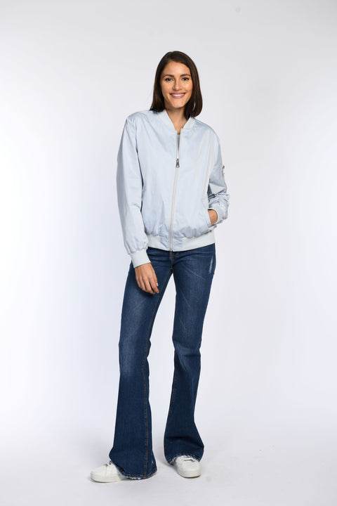 Model trägt locker geschnittenen blauen Blouson mit Stehkragen und 2-Wege-Reißverschluss.