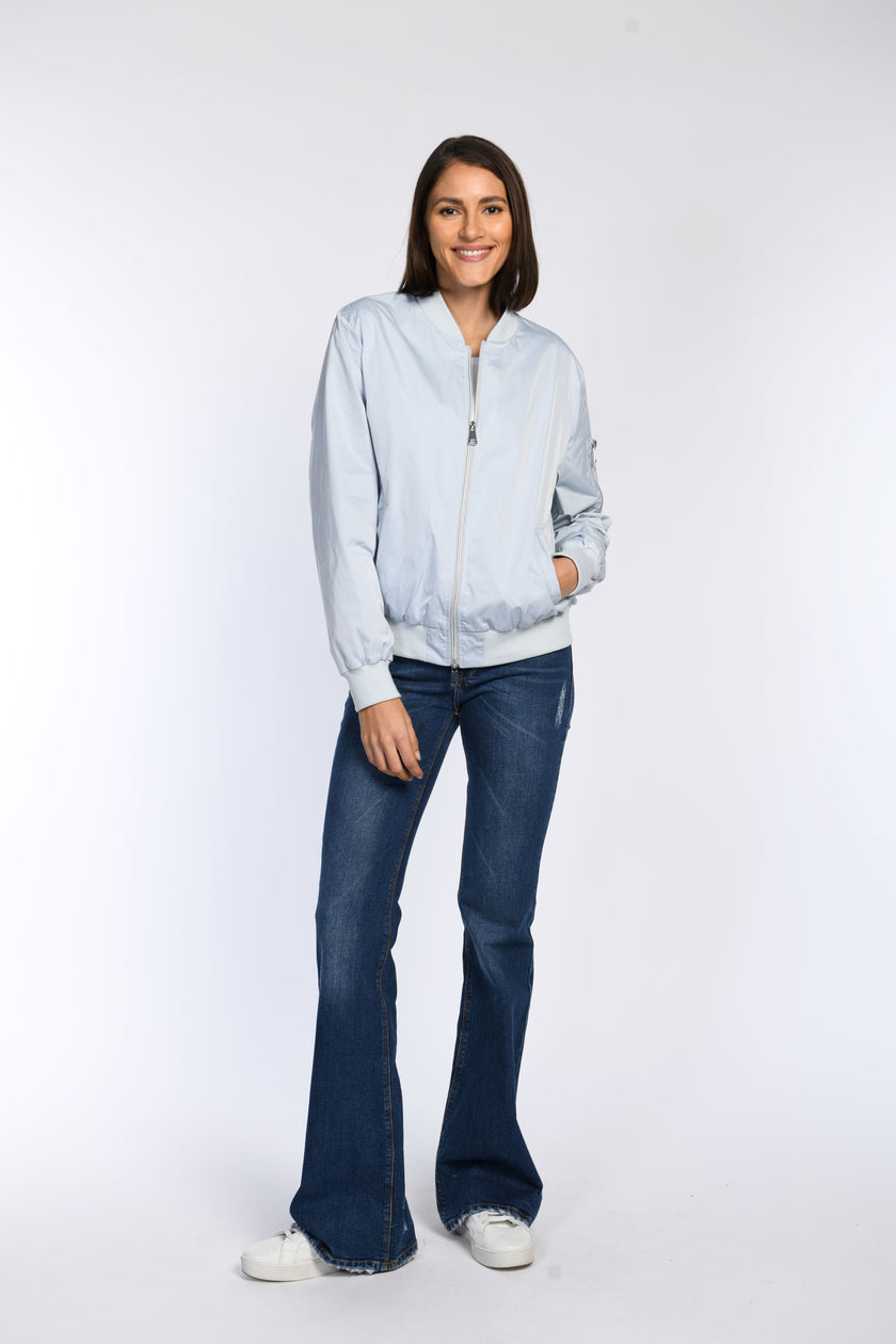 Model trägt locker geschnittenen blauen Blouson mit Stehkragen und 2-Wege-Reißverschluss.