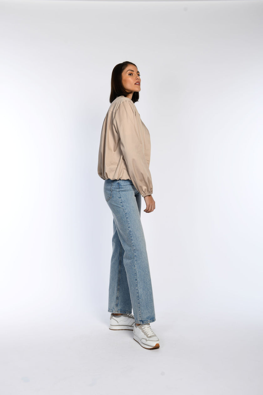 Model trägt taupefarbenes Blouson mit weiten Ärmeln – Seitenansicht.