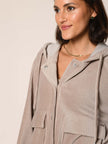Model trägt Baumwoll Jersey Cord Blouson mit Kapuze in der Farbe Beige - Detailansicht.