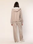 Model trägt Baumwoll Jersey Cord Blouson mit Kapuze in der Farbe Beige - Rückansicht.
