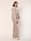 Model trägt Baumwoll Jersey Cord Blouson mit Kapuze in der Farbe Beige - Seitenansicht.