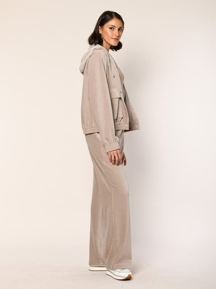 Model trägt Baumwoll Jersey Cord Blouson mit Kapuze in der Farbe Beige - Seitenansicht.