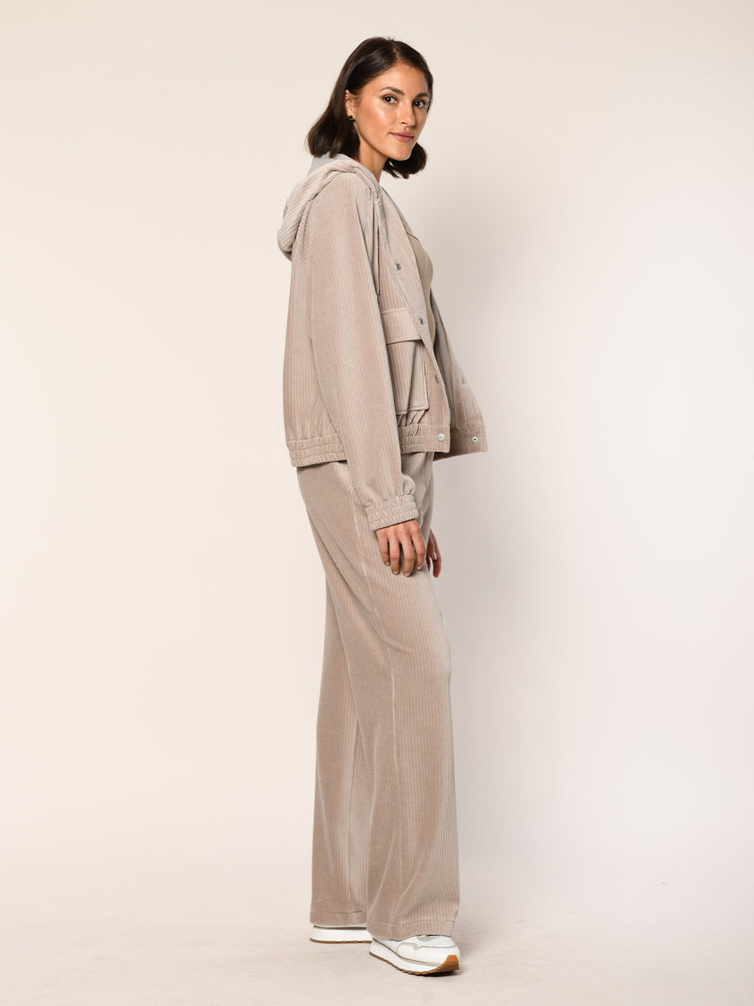 Model trägt Baumwoll Jersey Cord Blouson mit Kapuze in der Farbe Beige - Seitenansicht.
